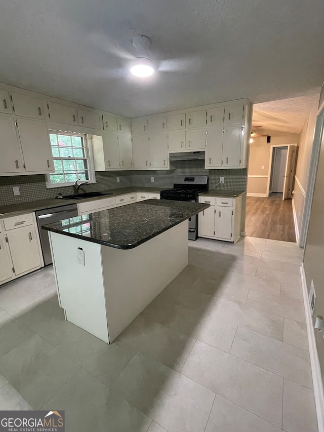 kitchen featuring a kitchen island, appliances with stainless steel finishes, white cabinetry, and light tile patterned floors