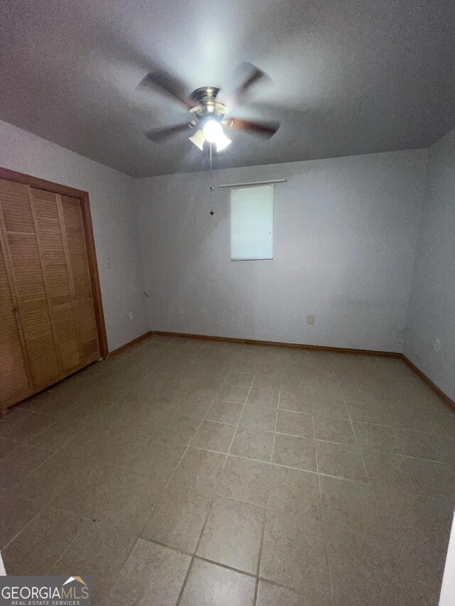 unfurnished bedroom with a textured ceiling, a closet, light tile patterned floors, and ceiling fan