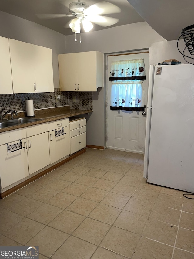 kitchen featuring light tile patterned flooring, white refrigerator, tasteful backsplash, ceiling fan, and sink