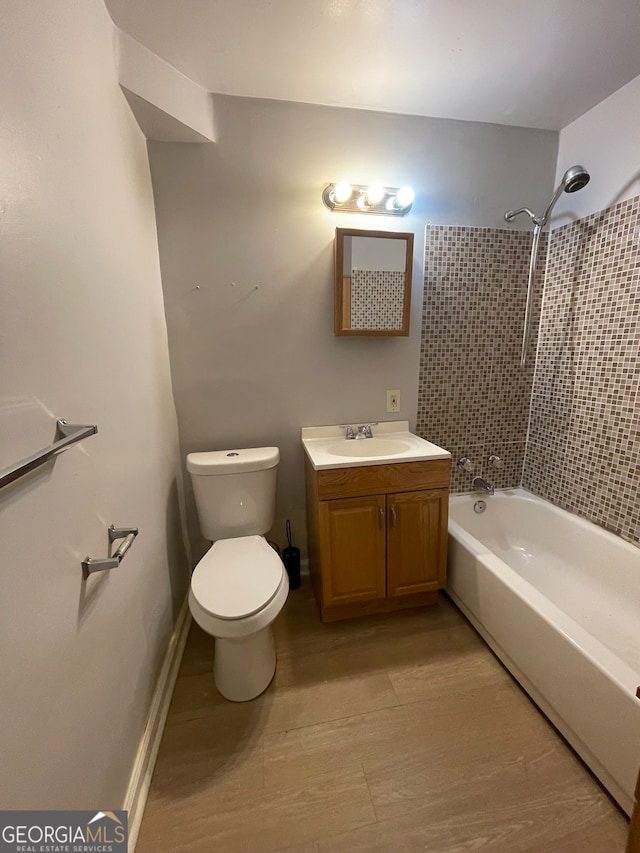 full bathroom featuring toilet, vanity, and tiled shower / bath