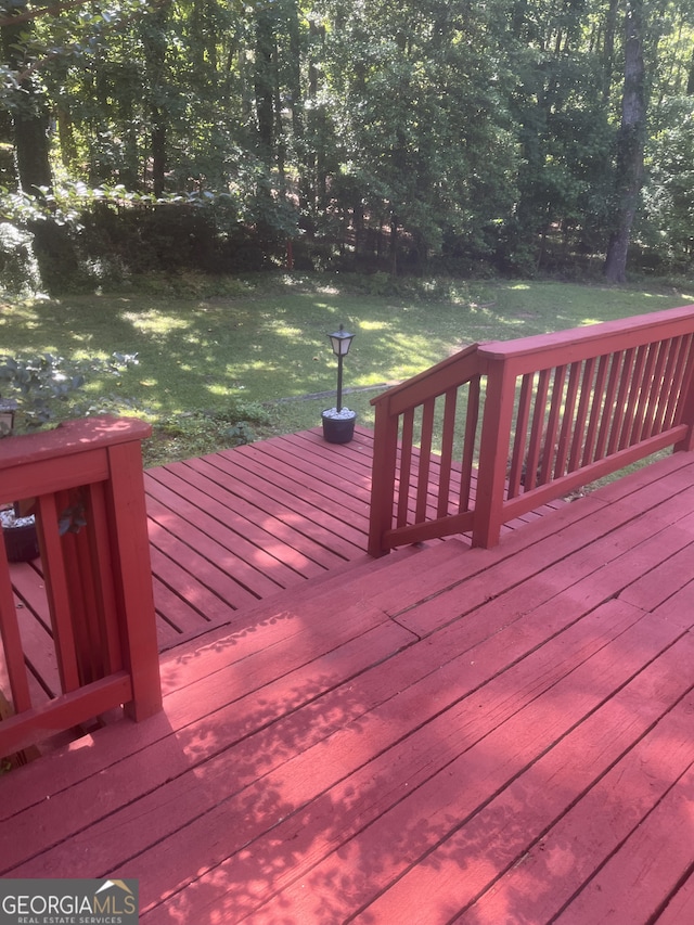 wooden terrace featuring a yard