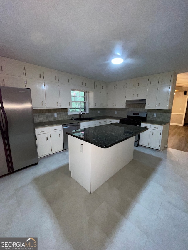 kitchen featuring stainless steel appliances, sink, light wood-type flooring, a center island, and white cabinetry