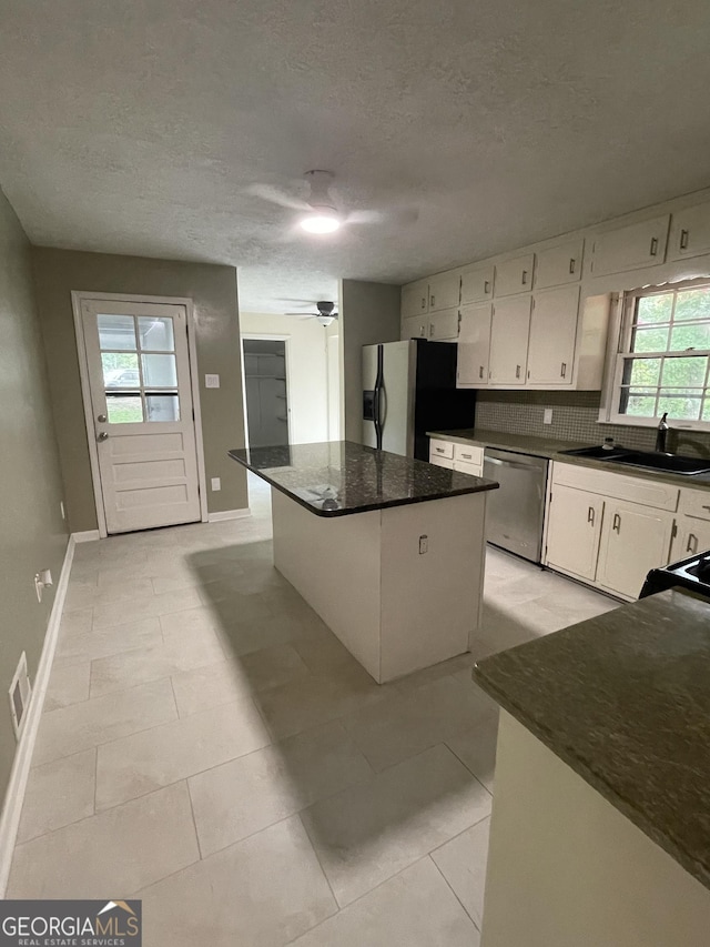 kitchen with white cabinetry, ceiling fan, sink, a kitchen island, and appliances with stainless steel finishes