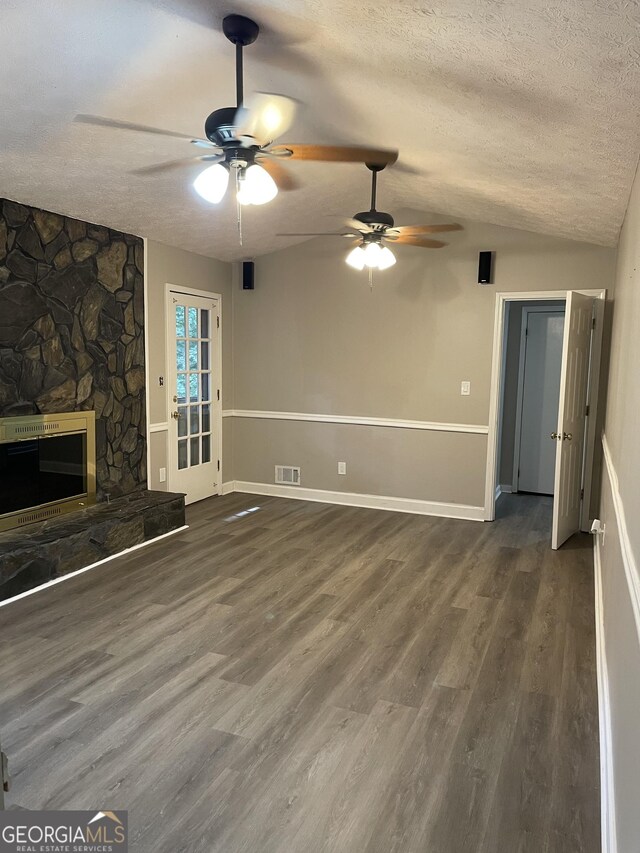 unfurnished living room with a fireplace, hardwood / wood-style flooring, ceiling fan, vaulted ceiling, and a textured ceiling