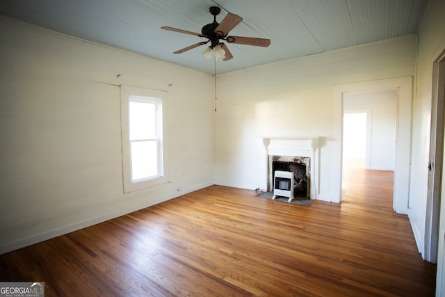 unfurnished living room featuring heating unit, light hardwood / wood-style floors, and ceiling fan