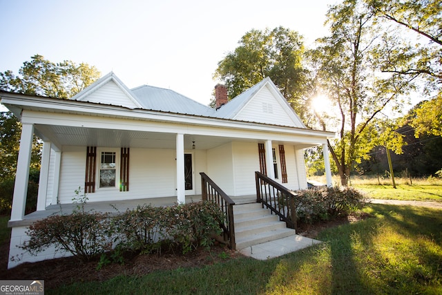 farmhouse inspired home with a front yard and covered porch