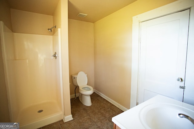 bathroom with toilet, walk in shower, and vanity