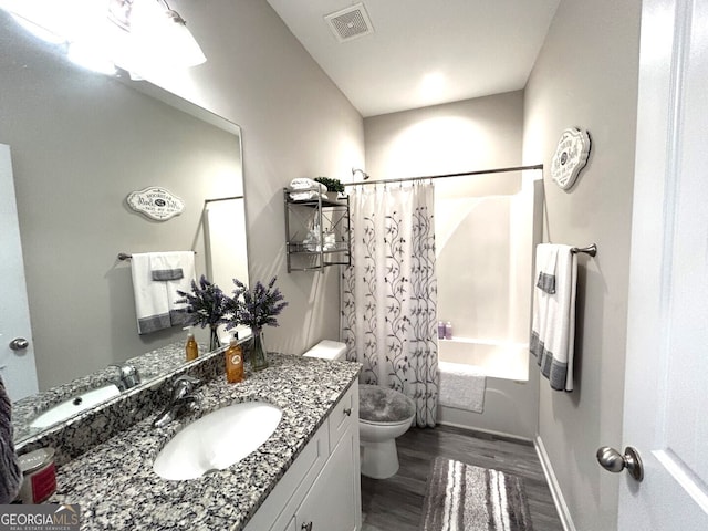 full bathroom featuring vanity, toilet, hardwood / wood-style flooring, and shower / tub combo