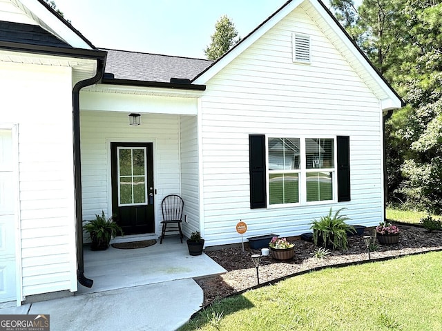 doorway to property featuring a lawn