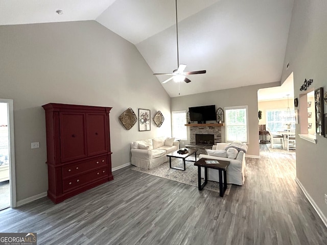 living room with a stone fireplace, ceiling fan, hardwood / wood-style flooring, and high vaulted ceiling