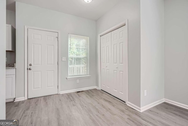 unfurnished bedroom with light hardwood / wood-style flooring and a closet