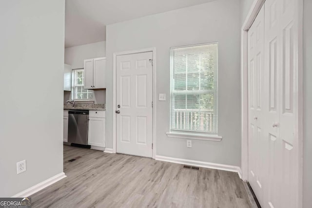 interior space with baseboards, visible vents, and light wood-style floors