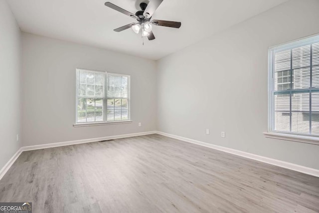unfurnished room with ceiling fan, a healthy amount of sunlight, and wood finished floors