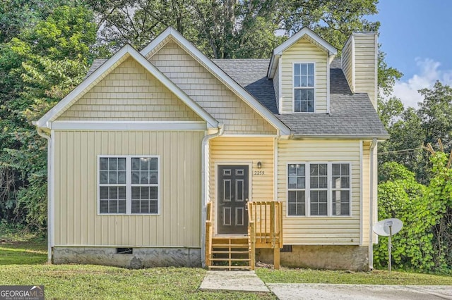 view of front of home with crawl space, a shingled roof, a chimney, and a front lawn
