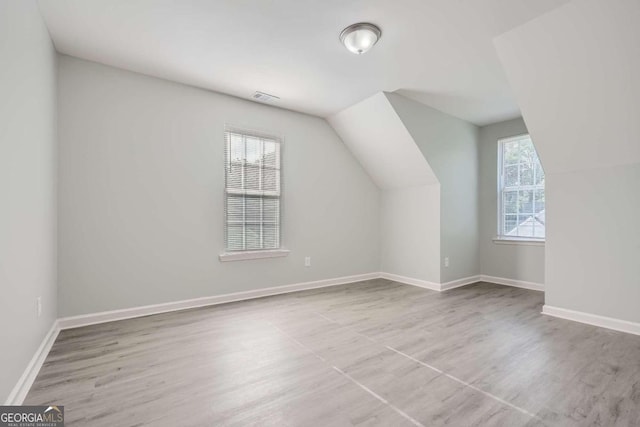 bonus room with lofted ceiling and light hardwood / wood-style flooring