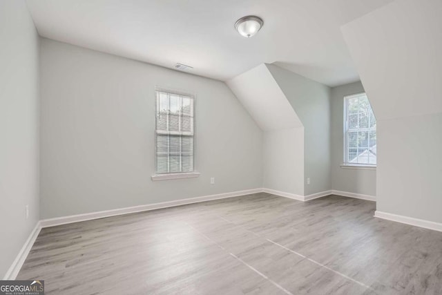 bonus room featuring vaulted ceiling, baseboards, wood finished floors, and visible vents
