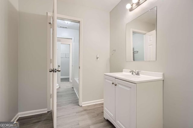 bathroom featuring wood-type flooring, toilet, and vanity