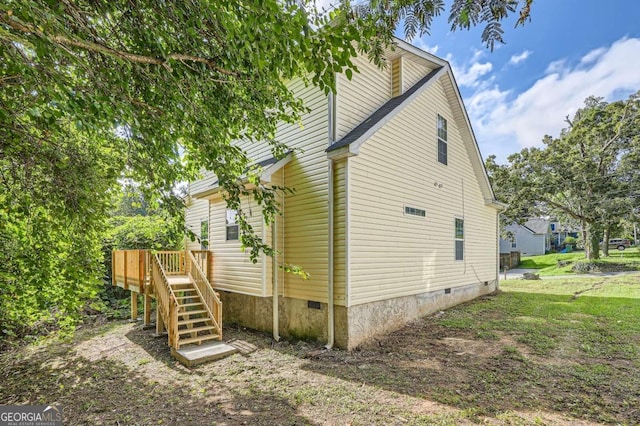 view of side of home featuring crawl space, stairway, and a deck