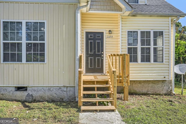 property entrance with a shingled roof