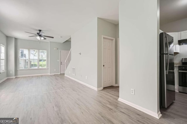 unfurnished living room featuring ceiling fan and light hardwood / wood-style flooring