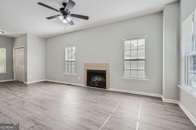 unfurnished living room with light hardwood / wood-style floors, ceiling fan, and a wealth of natural light