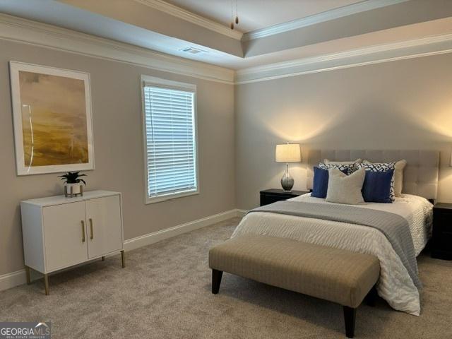 carpeted bedroom with crown molding and a tray ceiling