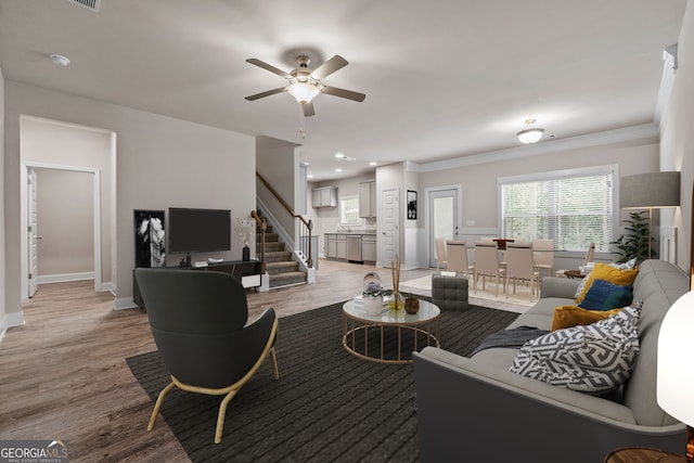 living room with ornamental molding, ceiling fan, and light hardwood / wood-style floors