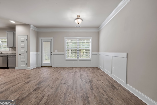 unfurnished dining area with crown molding, plenty of natural light, and hardwood / wood-style floors