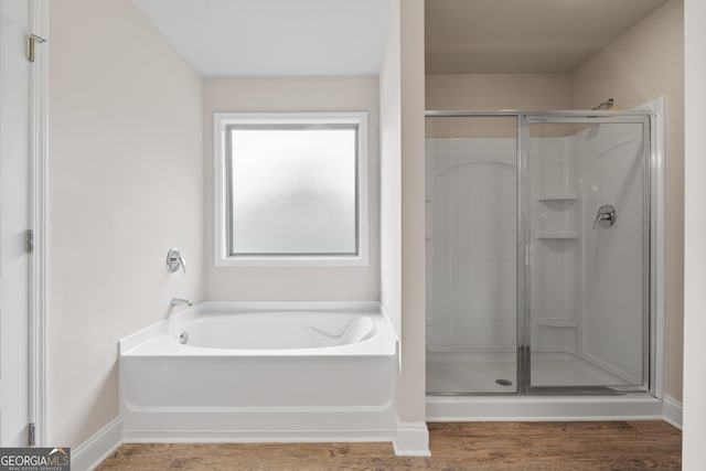 bathroom with hardwood / wood-style flooring and independent shower and bath