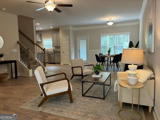 living room with hardwood / wood-style flooring, ceiling fan, and crown molding