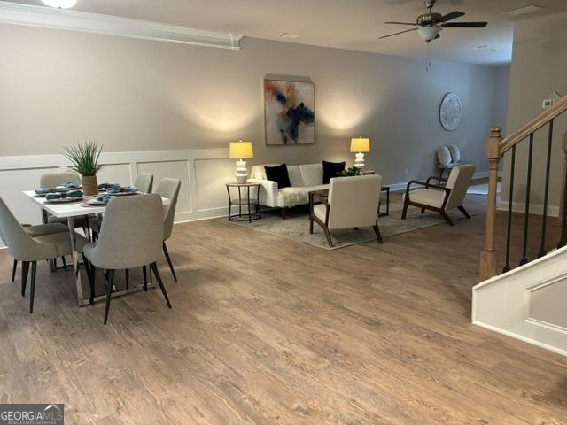 dining room with hardwood / wood-style flooring, ceiling fan, and ornamental molding