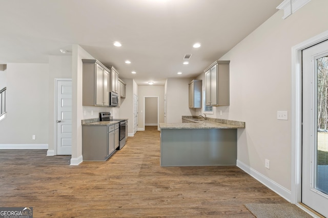 kitchen featuring hardwood / wood-style flooring, appliances with stainless steel finishes, sink, and gray cabinetry