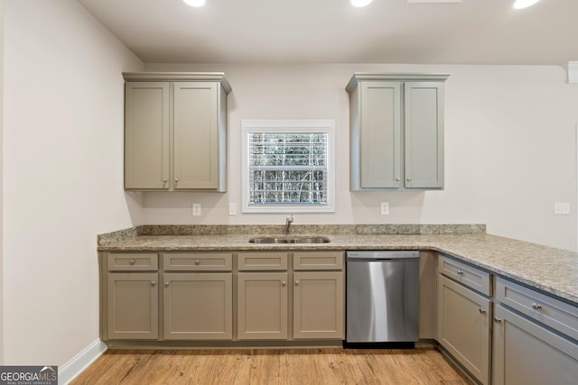 kitchen with light stone counters, sink, stainless steel dishwasher, and light hardwood / wood-style floors