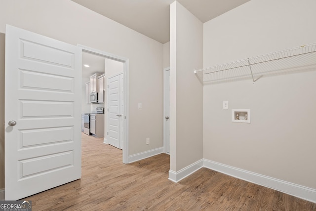 washroom featuring hookup for a washing machine and light hardwood / wood-style floors