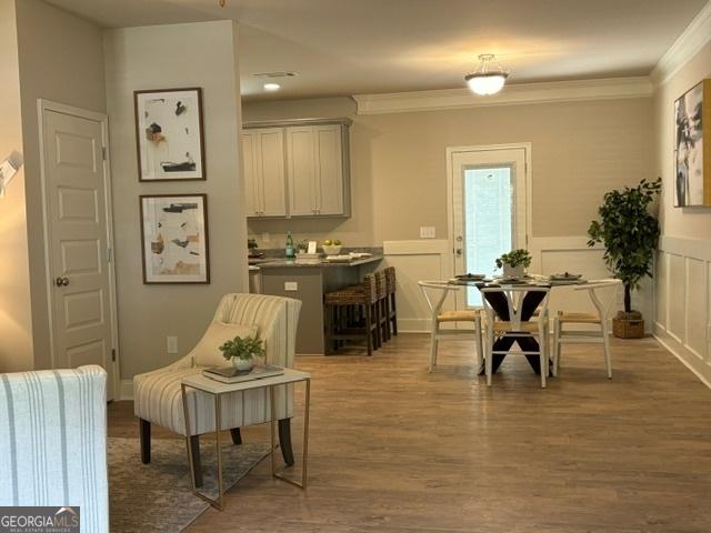 sitting room with hardwood / wood-style floors and ornamental molding