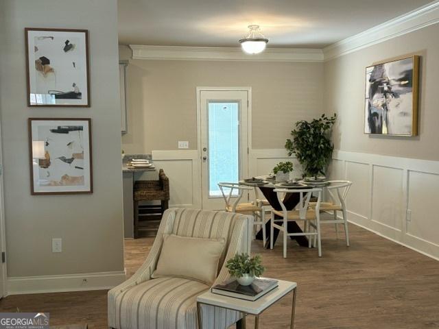 living area featuring crown molding and dark wood-type flooring