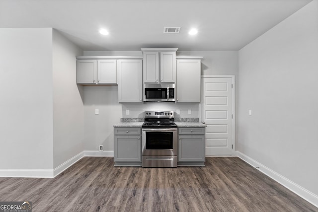 kitchen featuring dark wood-type flooring, gray cabinets, and appliances with stainless steel finishes