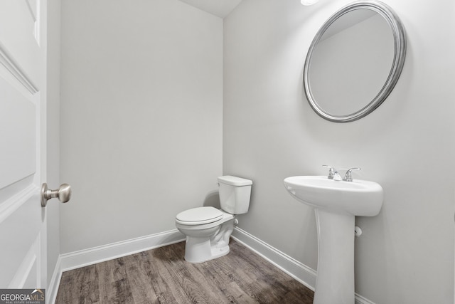 bathroom with hardwood / wood-style floors, sink, and toilet