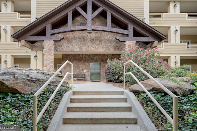 view of exterior entry with a balcony