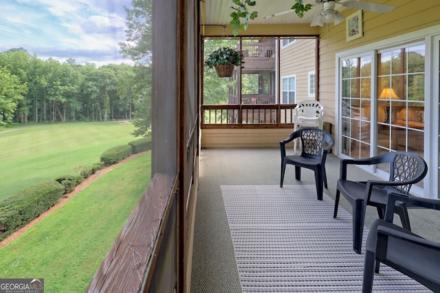 deck with a lawn and ceiling fan