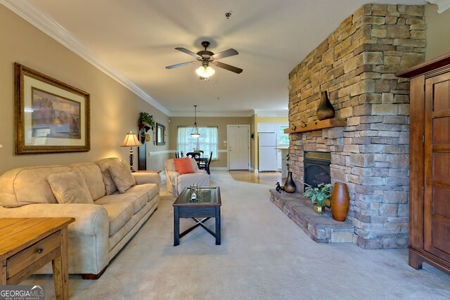 carpeted living room featuring a fireplace, ornamental molding, and ceiling fan