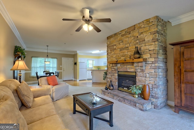 living room featuring a stone fireplace, ornamental molding, a wealth of natural light, and ceiling fan