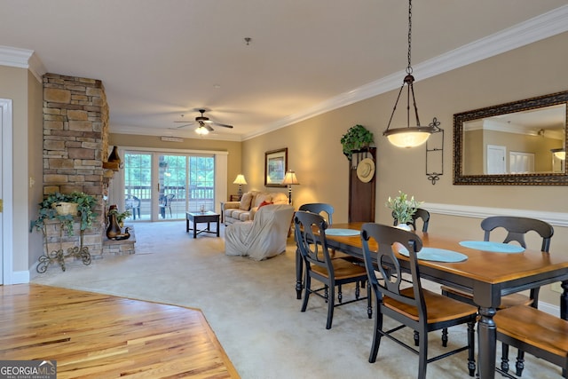 dining space with light carpet, crown molding, and ceiling fan