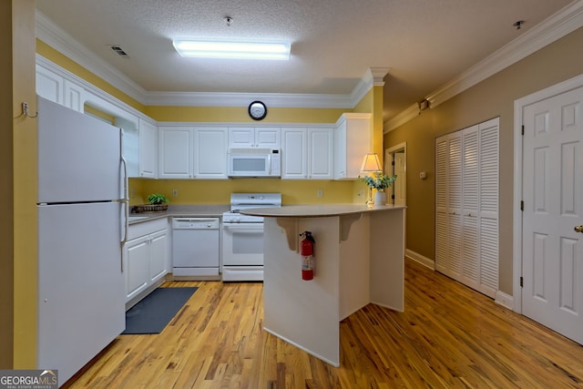 kitchen with light hardwood / wood-style flooring, white appliances, a textured ceiling, white cabinetry, and ornamental molding