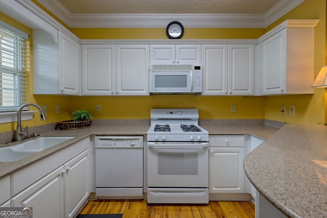 kitchen featuring ornamental molding, sink, white cabinetry, and white appliances