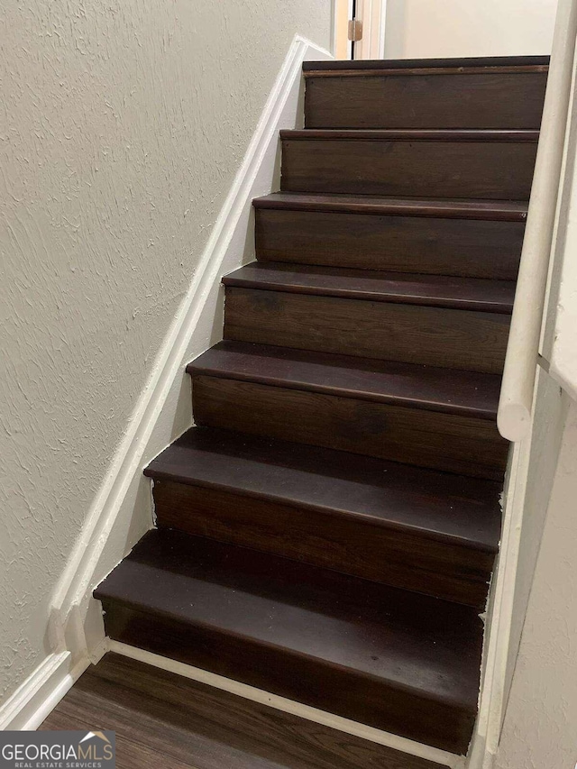 staircase with hardwood / wood-style flooring