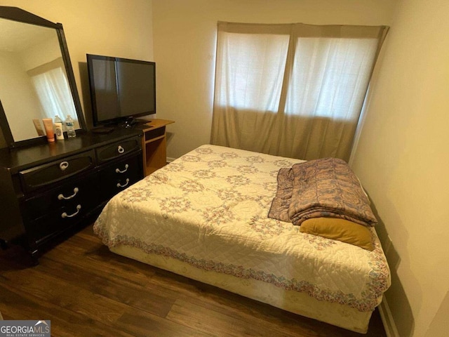 bedroom with dark hardwood / wood-style flooring