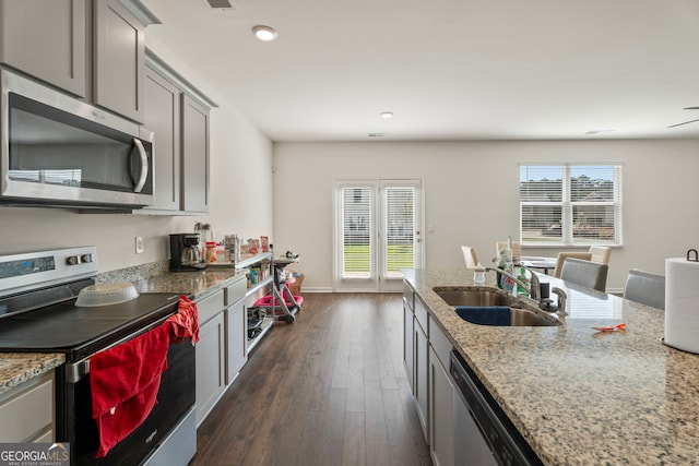 kitchen featuring light stone counters, sink, gray cabinets, and stainless steel appliances