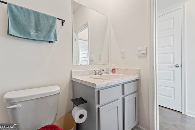 bathroom with vanity, hardwood / wood-style flooring, and toilet