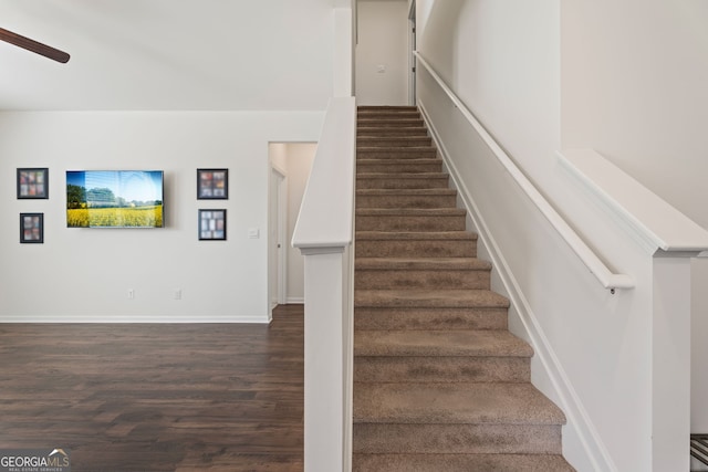 stairs with hardwood / wood-style floors and ceiling fan